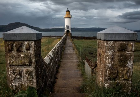 Tobermory Lighthouse, in the Isle of Mull, with stone wall and path leading to the lighthouse in the background. Leading lines. Vanishing point. Argyll and Bute, Scotland
