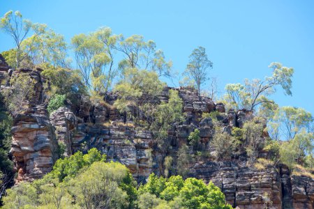 Rugged Outback scenery featuring rocky outcrops and dense bushland. Perfect for travel, nature, and adventure projects highlighting Australia's wild beauty