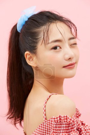 Retrato casual de una joven asiática fotografiada sobre un fondo rosa