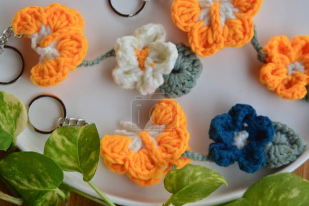Crochet Art, Yellow Butterfly and Flower Keychains in a Natural Setting,Yellow Butterfly Crochet Keychains,Floral Beauty on Brown Background