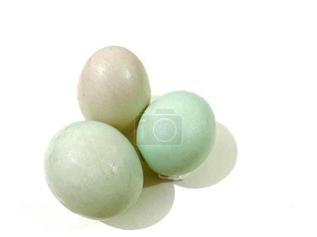 Tres huevos de pato frescos y crudos aislados sobre fondo blanco