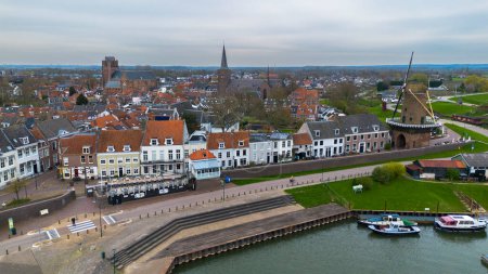 Beautiful view from above, from drone to orange, tiled roofs of houses. Top view of the Dutch city of Wijk bij Duurstede. The streets and roof of the church. Central Square of the city.