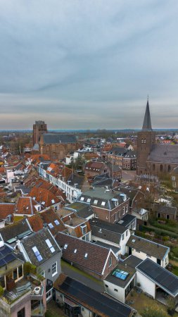 Beautiful view from above, from drone to orange, tiled roofs of houses. Top view of the Dutch city of Wijk bij Duurstede. The streets and roof of the church. Central Square of the city.