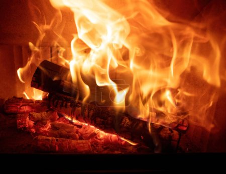 Feuerflammen und brennende Holzscheite, Kamin aus nächster Nähe, Warmes Zuhause im Winter, Vorderansicht