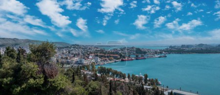 Greece, destination city of Chalkida at Evia. Close up view of Halkida port from castle, moored ship, building, Euripus Strait, cloudy sky background.