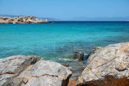 Téléchargez les photos : Plage d'Aponisos Grèce Agistri île. Vue dégagée sur grand rocher au bord de la mer, eau de mer turquoise, fond de plage rocheux flou. Jour d'été. - en image libre de droit
