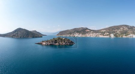 Foto de Grecia, Tolo cerca de Nafplio, Argorida, Peloponeso. Vista panorámica aérea del pueblo, pequeña isla, barco amarrado en el puerto, mar, cielo azul. Spac - Imagen libre de derechos