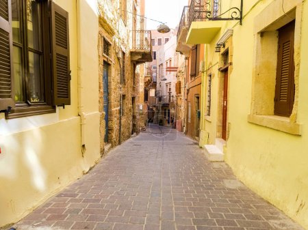 Chania Old Town, Crete island, destination Greece. Traditional narrow paved walkway between multicolor vintage building, summer sunny day.