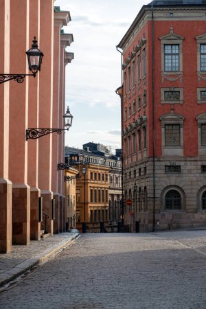 Axel Oxenstierna Palace en Estocolmo, Suecia. Parte de ornamentado edificio rojo de estilo manierista junto a imponente edificio en el casco antiguo. Vertical