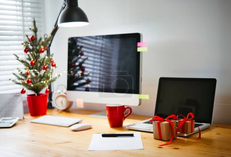 Téléchargez les photos : Arbre de Noël et ornement décoré sur une table de travail en bois. Freelance heures supplémentaires sur le nouveau concept de vacances de l'année - en image libre de droit
