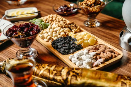 A wooden table is adorned with a diverse assortment of mouthwatering food items, creating an appetizing and enticing display.