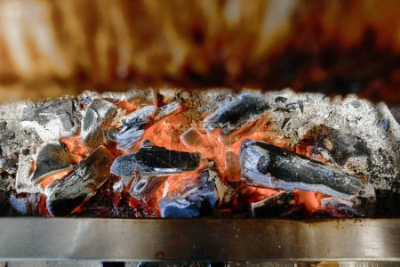 Foto de Una vista de cerca de una parrilla con varios tipos de cocción de alimentos en las rejillas calientes, como llamas lamer las superficies. - Imagen libre de derechos