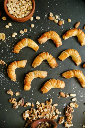A table showcasing an assortment of fresh croissants and a variety of nuts.