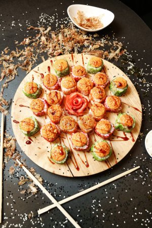 Photo for A table with a plate of various appetizers served with chopsticks. - Royalty Free Image