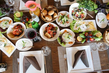 Stół pokryty mnóstwem talerzy wypełnionych pysznym jedzeniem i szklankami wypełnionymi winem.