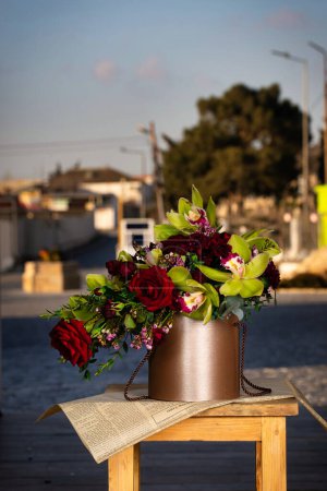 Ein schönes Arrangement von Blumen in einer Vase auf einem rustikalen Holztisch, mit großzügigem Kopierraum.