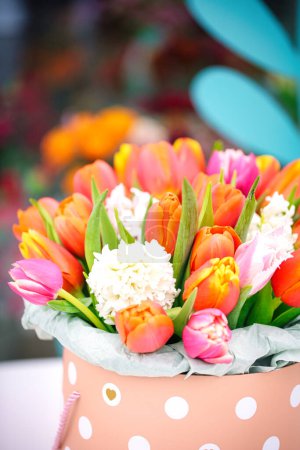 Un bouquet de fleurs accrocheur présenté dans un charmant vase à pois, parfait pour ajouter une touche vibrante à n'importe quel espace.