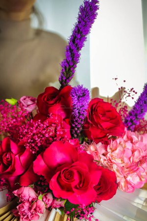 Un beau vase débordant de fleurs rouges et roses, offrant un ravissant éclat de couleur.