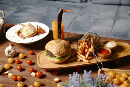 Téléchargez les photos : Un plateau en bois surmonté d'un délicieux sandwich et d'un côté de frites croustillantes. - en image libre de droit
