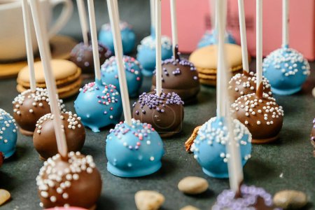 Photo for A table is filled with a variety of cake pops covered in rich chocolate coatings. - Royalty Free Image