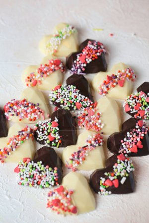Téléchargez les photos : Une collection de chocolats en forme de cœur ornée de paillettes vibrantes, créant une image délicieuse et appétissante. - en image libre de droit
