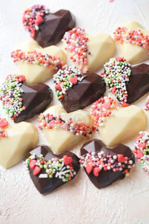 Téléchargez les photos : Une variété de chocolats en forme de cœur exposés avec goût sur une table. - en image libre de droit