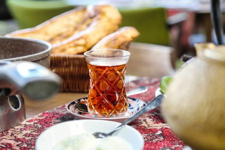 Un verre de thé rafraîchissant est placé sur une table en bois robuste.