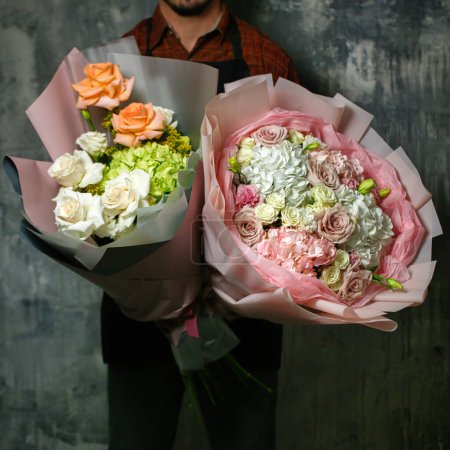 Téléchargez les photos : Un homme pose avec deux bouquets abondants de fleurs, offrant beaucoup d'espace pour copier. - en image libre de droit