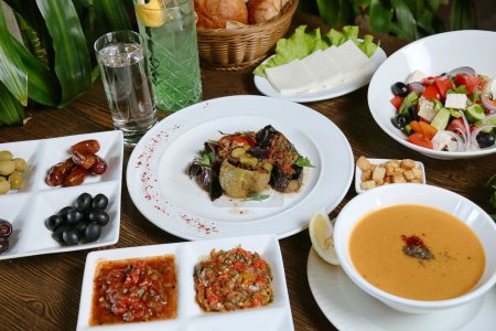 A table adorned with a variety of plates filled with delicious food, accompanied by steaming bowls of soup.