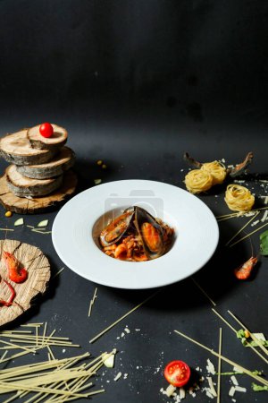 Téléchargez les photos : Une assiette remplie de délicieux aliments placés sur une table noire élégante. - en image libre de droit