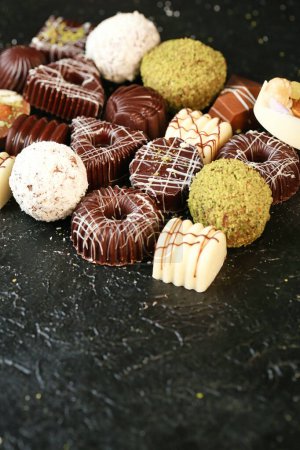 A collection of various chocolates arranged in a heap on a countertop.