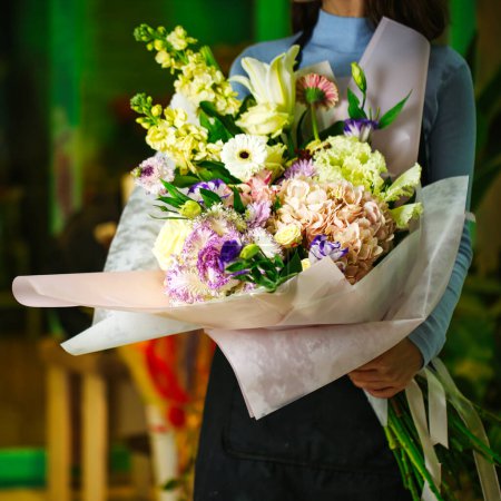 Téléchargez les photos : Une femme tient gracieusement un beau bouquet de fleurs. - en image libre de droit