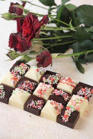 A close-up shot showcasing a variety of chocolates in different shapes and flavors, beautifully decorated with vibrant sprinkles.