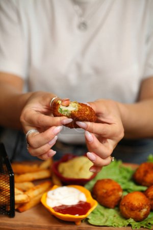 Eine Person hält ein Stück Essen in der Hand und bereitet sich darauf vor, es zu essen.