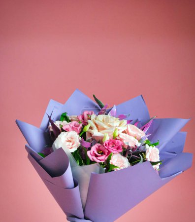 A beautiful bouquet of flowers elegantly wrapped in purple paper, with plenty of copy space.