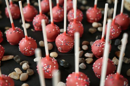 A bunch of delectable cake pops covered in a variety of vibrant sprinkles.