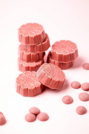 Une photo d'un tas de pilules roses soigneusement disposées sur une table.