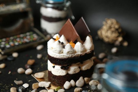 A chocolate cake with fluffy marshmallow topping sitting on a table.