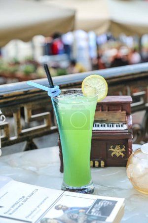 A refreshing green drink stands on top of a wooden table, creating a vibrant and invigorating scene.