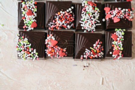 The photo showcases a variety of chocolate pieces adorned with colorful sprinkles.