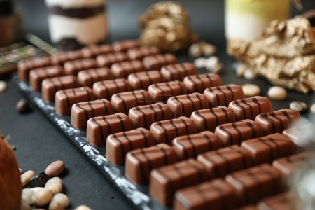 A table adorned with a wide variety of chocolates and nuts, tempting with their rich flavors and textures.