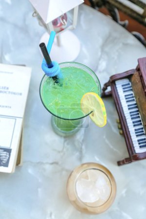 Téléchargez les photos : Un verre de boisson verte est placé sur une table en bois, offrant une option de boisson rafraîchissante et saine. - en image libre de droit