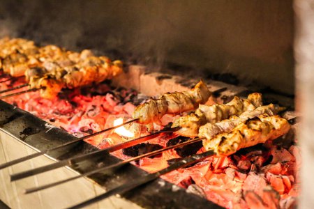 Several skewers of assorted food items grilling on a hot grill, creating delicious aromas.