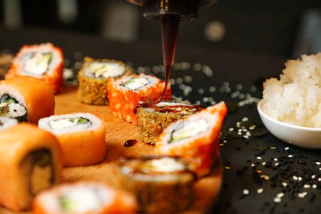 Ein Teller gefüllt mit Sushi-Rollen und einer Schüssel Reis, der eine traditionelle japanische Mahlzeit präsentiert.