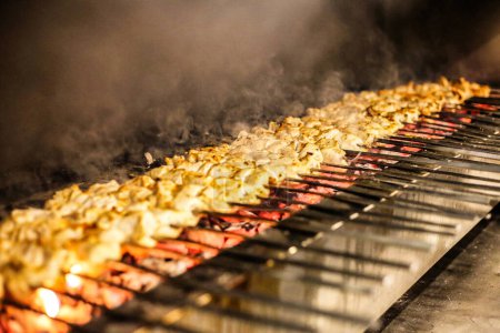 A grill filled with a delicious assortment of meats and vegetables cooking over an open flame.