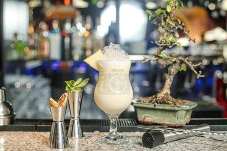 Une vue détaillée d'une boisson cocktail vibrante placée sur un comptoir de bar bien éclairé.