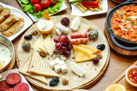 Eine vielfältige Auswahl an Käse und Fleisch auf einem Tisch, die eine Reihe von Geschmacksrichtungen und Texturen bietet.