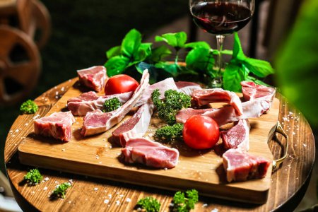 A wooden cutting board showcasing an assortment of meats and fresh vegetables for meal preparation.