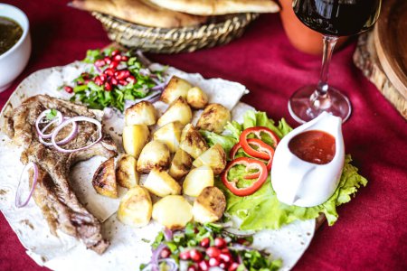 A mouthwatering assortment of food, including a variety of dishes, served on a plate accompanied by a tempting glass of wine, arranged on a table.