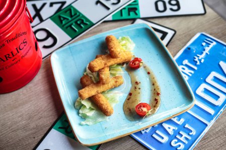 Téléchargez les photos : Une assiette bleue avec un repas appétissant se trouve sur une table en bois robuste. - en image libre de droit